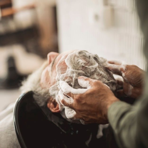 Premium Photo _ Barber massaging shampoo into client hair